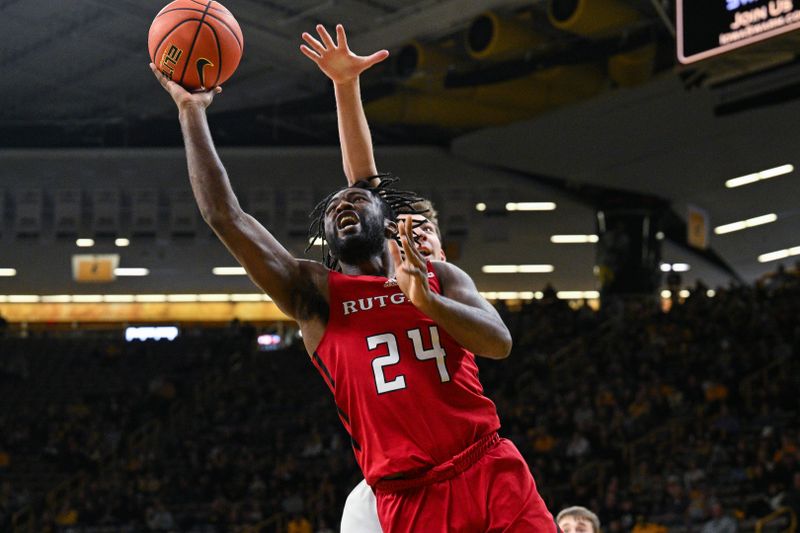 Jan 6, 2024; Iowa City, Iowa, USA; Rutgers Scarlet Knights guard Austin Williams (24) goes to the basket as Iowa Hawkeyes forward Pryce Sandfort (24) defends during the first half at Carver-Hawkeye Arena. Mandatory Credit: Jeffrey Becker-USA TODAY Sports