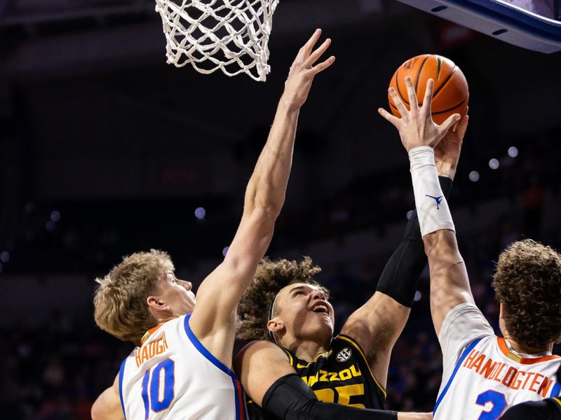 Feb 28, 2024; Gainesville, Florida, USA; Missouri Tigers forward Noah Carter (35) attempts a layup over Florida Gators forward Thomas Haugh (10) and center Micah Handlogten (3) during the first half at Exactech Arena at the Stephen C. O'Connell Center. Mandatory Credit: Matt Pendleton-USA TODAY Sports