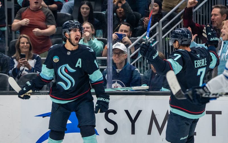 Oct 24, 2024; Seattle, Washington, USA; Seattle Kraken forward Matty Beniers (10) celebrates with forward Jordan Eberle (7) after scoring a goal during the first period against the Winnipeg Jets at Climate Pledge Arena. Mandatory Credit: Stephen Brashear-Imagn Images