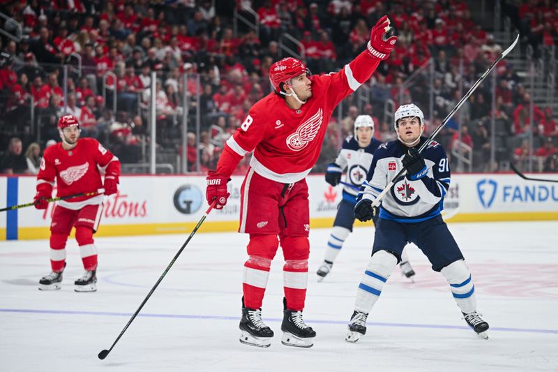 Oct 30, 2024; Detroit, Michigan, USA; Detroit Red Wings defenseman Ben Chiarot (8) catches the puck as Winnipeg Jets center Cole Perfetti (91) defends during the first period at Little Caesars Arena. Mandatory Credit: Tim Fuller-Imagn Images