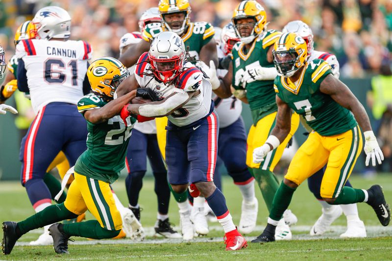 Green Bay Packers safety Darnell Savage (26) tackles New England Patriots running back Rhamondre Stevenson (38) during the second half of an NFL football game, Sunday, Oct. 2, 2022, in Green Bay, Wis. (AP Photo/Kamil Krzaczynski)