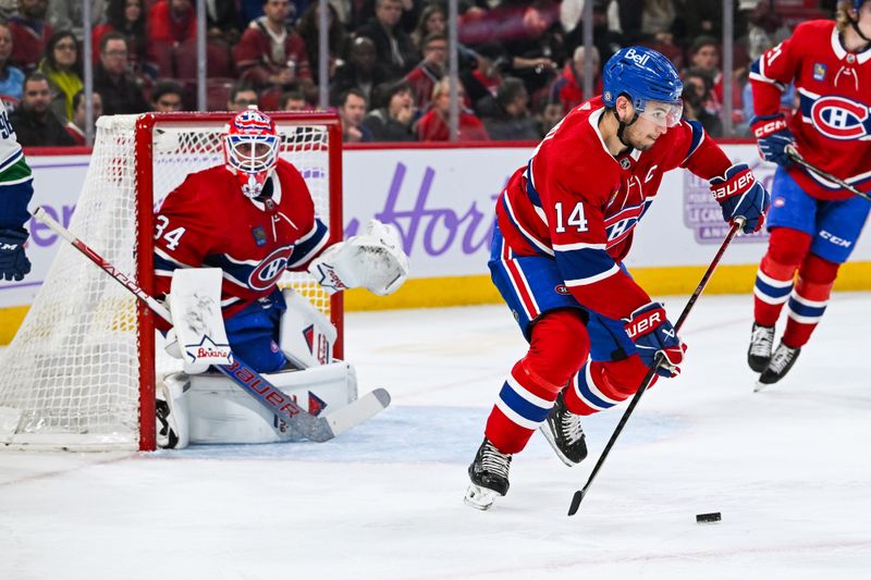 Nov 12, 2023; Montreal, Quebec, CAN; Montreal Canadiens center Nick Suzuki (14) escapes with the puck against the Vancouver Canucks during the first period at Bell Centre. Mandatory Credit: David Kirouac-USA TODAY Sports