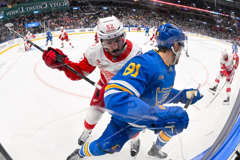 Oct 28, 2025; St. Louis, Missouri, USA; Detroit Red Wings defenseman Travis Hamonic (52) checks St. Louis Blues left wing Dylan Holloway (81) during the second period at Enterprise Center. Mandatory Credit: Jeff Curry-Imagn Images