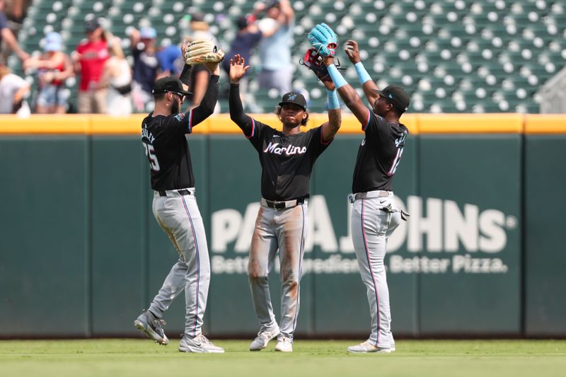 Aug 4, 2024; Cumberland, Georgia, USA; Miami Marlins second baseman David Hensley (25), center fielder Christian Pache (20), and right fielder Jesus Sanchez (12) celebrate after a win against the Atlanta Braves at Truist Park. Mandatory Credit: Mady Mertens-USA TODAY Sports