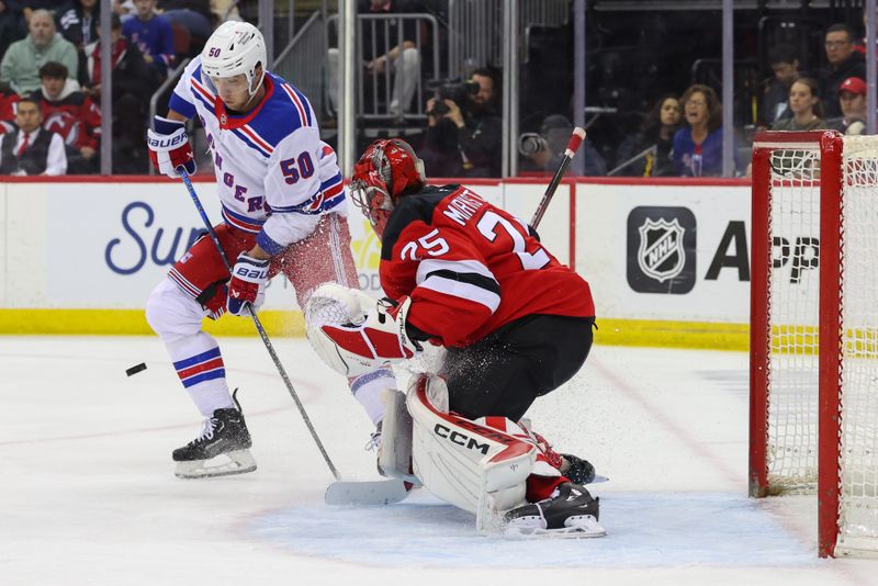 Apr 5, 2025; Newark, New Jersey, USA; New York Rangers left wing Will Cuylle (50) tries to play the puck in front of New Jersey Devils goaltender Jacob Markstrom (25) during the first period at Prudential Center. Mandatory Credit: Ed Mulholland-Imagn Images