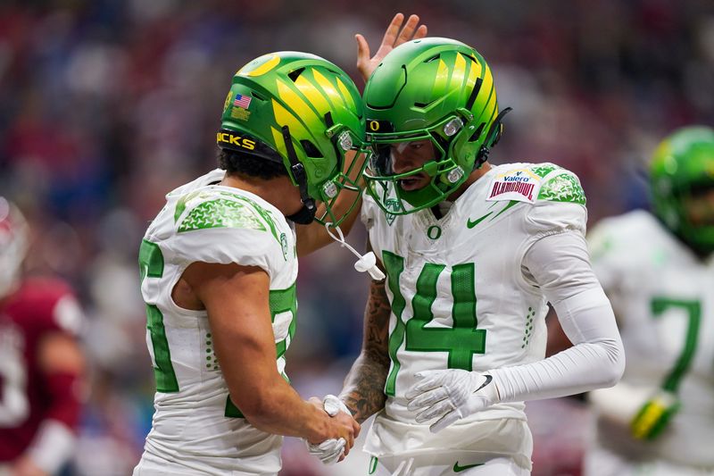 Dec 29, 2021; San Antonio, Texas, USA; Oregon Ducks wide receiver Kris Hutson (14) congratulates running back Travis Dye (26) after a score during the second half of the 2021 Alamo Bowl against the Oklahoma Sooners at the Alamodome. Mandatory Credit: Daniel Dunn-USA TODAY Sports