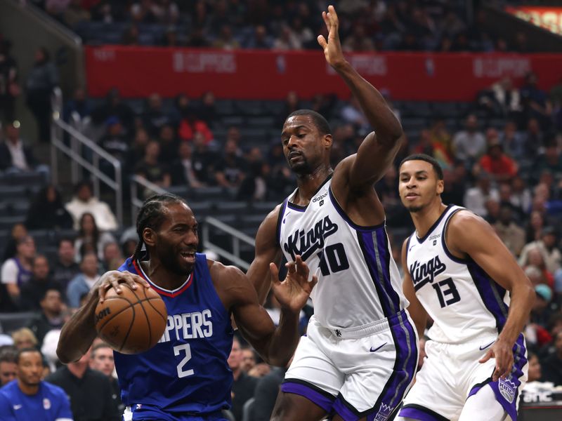 LOS ANGELES, CALIFORNIA - DECEMBER 12: Kawhi Leonard #2 of the LA Clippers reacts as he is guarded by Harrison Barnes #40 and Keegan Murray #13 of the Sacramento Kings during the first half at Crypto.com Arena on December 12, 2023 in Los Angeles, California.  NOTE TO USER: User expressly acknowledges and agrees that, by downloading and or using this photograph, User is consenting to the terms and conditions of the Getty Images License Agreement. (Photo by Harry How/Getty Images)