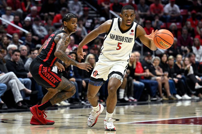 Jan 6, 2024; San Diego, California, USA; San Diego State Aztecs guard Lamont Butler (5) dribbles the ball past UNLV Rebels guard Luis Rodriguez (15) during the first half at Viejas Arena. Mandatory Credit: Orlando Ramirez-USA TODAY Sports