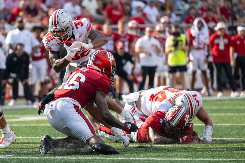 Sep 2, 2023; Bloomington, Indiana, USA; Ohio State Buckeyes running back TreVeyon Henderson (32) evades tackle by Indiana Hoosiers defensive back Jordan Grier (16) during the second half at Memorial Stadium. Mandatory Credit: Marc Lebryk-USA TODAY Sports