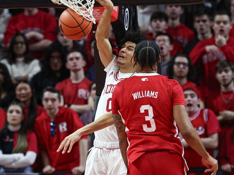 Jan 17, 2024; Piscataway, New Jersey, USA; Rutgers Scarlet Knights guard Derek Simpson (0) dunks the ball in front of Nebraska Cornhuskers guard Brice Williams (3) during the first half at Jersey Mike's Arena. Mandatory Credit: Vincent Carchietta-USA TODAY Sports