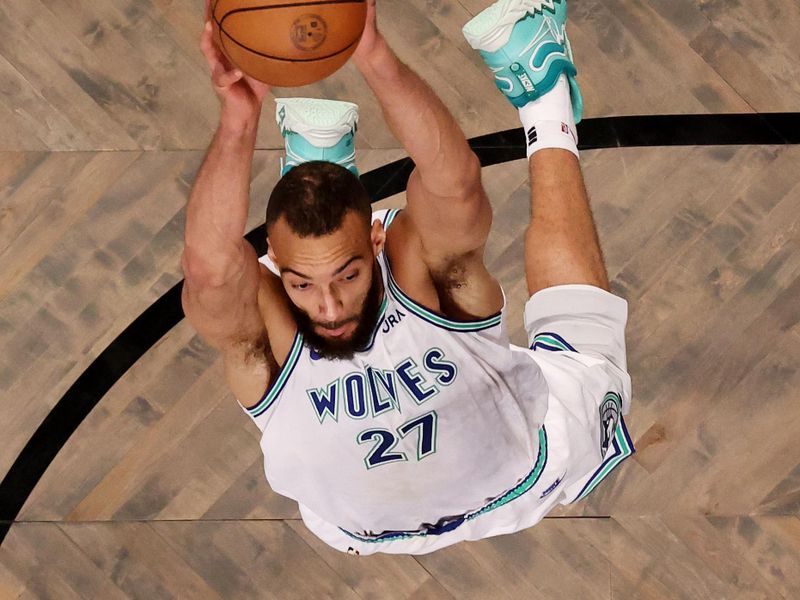 NEW YORK, NEW YORK - JANUARY 25:  Rudy Gobert #27 of the Minnesota Timberwolves dunks against Nic Claxton #33 of the Brooklyn Nets and Cameron Johnson #2 of the Brooklyn Nets during their game at Barclays Center on January 25, 2024 in New York City.  User expressly acknowledges and agrees that, by downloading and or using this photograph, User is consenting to the terms and conditions of the Getty Images License Agreement.  (Photo by Al Bello/Getty Images)