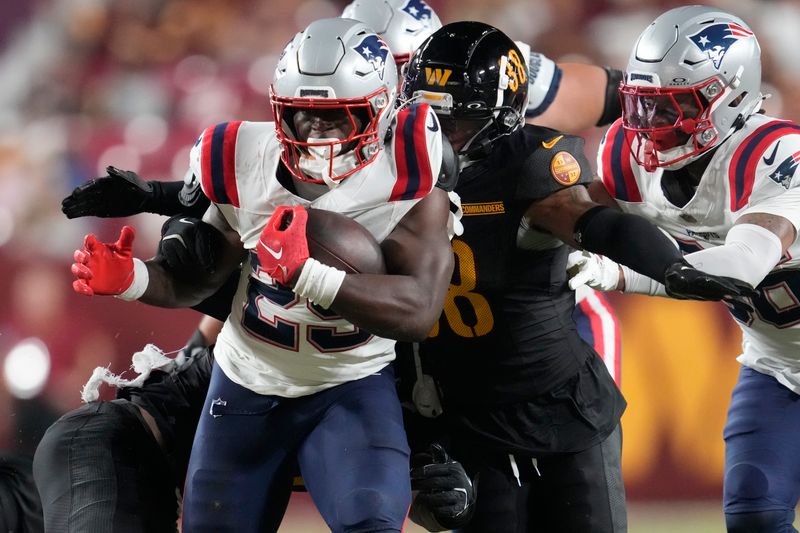 New England Patriots running back Terrell Jennings, left, runs against Washington Commanders cornerback A.J. Woods during the second half of a preseason NFL football game, Sunday, Aug. 25, 2024, in Landover, Md. (AP Photo/George Walker IV)