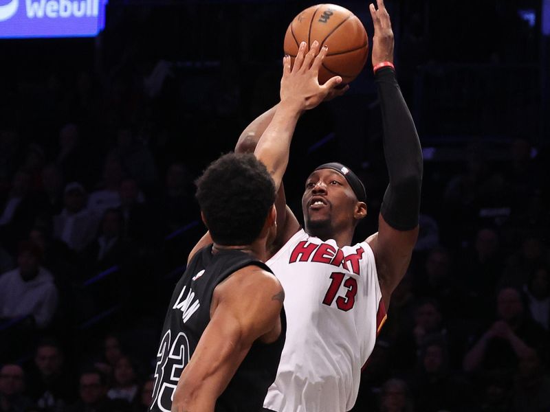 NEW YORK, NEW YORK - JANUARY 15:  Bam Adebayo #13 of the Miami Heat shoots against Nic Claxton #33 of the Brooklyn Nets during their game at Barclays Center on January 15, 2024 in New York City.   User expressly acknowledges and agrees that, by downloading and or using this photograph, User is consenting to the terms and conditions of the Getty Images License Agreement.  (Photo by Al Bello/Getty Images)