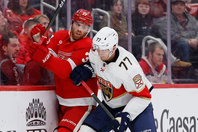 Mar 2, 2024; Detroit, Michigan, USA; Florida Panthers defenseman Niko Mikkola (77) checks Detroit Red Wings left wing J.T. Compher (37) in the second period at Little Caesars Arena. Mandatory Credit: Rick Osentoski-USA TODAY Sports