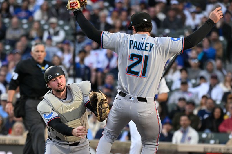 May 12, 2025; Chicago, Illinois, USA;   Miami Marlins third base Graham Pauley (21) catches a fly ball in foul territory hit by Chicago Cubs outfielder Seiya Suzuki (27) as  catcher Liam Hicks (34) assists during the first inning at Wrigley Field. Mandatory Credit: Matt Marton-Imagn Images