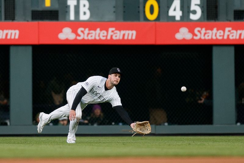 May 10, 2024; Denver, Colorado, USA; Colorado Rockies right fielder Sean Bouchard (12) dives for a fly ball in the fifth inning against the Texas Rangers at Coors Field. Mandatory Credit: Isaiah J. Downing-USA TODAY Sports