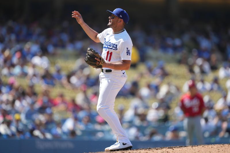 Jul 30, 2023; Los Angeles, California, USA; Los Angeles Dodgers shortstop Miguel Rojas (11) pitches in the ninth inning against the Cincinnati Reds at Dodger Stadium. Mandatory Credit: Kirby Lee-USA TODAY Sports