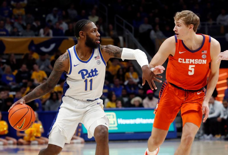 Jan 7, 2023; Pittsburgh, Pennsylvania, USA;  Pittsburgh Panthers guard Jamarius Burton (11) handles the ball against Clemson Tigers forward Hunter Tyson (5) during the first half at the Petersen Events Center. Mandatory Credit: Charles LeClaire-USA TODAY Sports