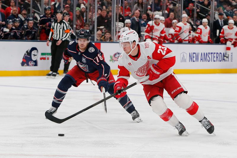 Dec 4, 2025; Columbus, Ohio, USA; Detroit Red Wings left wing Lucas Raymond (23) carries the puck as Columbus Blue Jackets defenseman Damon Severson (78) defends during the third period at Nationwide Arena. Mandatory Credit: Russell LaBounty-Imagn Images