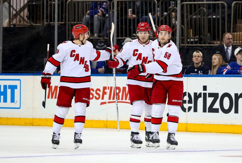 Jan 2, 2024; New York, New York, USA; Carolina Hurricanes left wing Michael Bunting (58) celebrates his goal with left wing Brendan Lemieux (28) and center Jack Drury (18) during the third period against the New York Rangers at Madison Square Garden. Mandatory Credit: Danny Wild-USA TODAY Sports