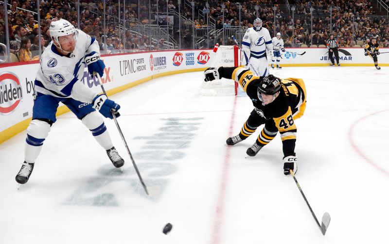 Apr 6, 2024; Pittsburgh, Pennsylvania, USA;  Tampa Bay Lightning defenseman Darren Raddysh (43) clears the puck against Pittsburgh Penguins right wing Valtteri Puustinen (48) during the first period at PPG Paints Arena. Mandatory Credit: Charles LeClaire-USA TODAY Sports