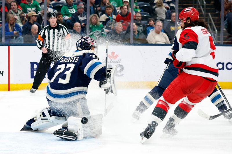 Mar 17, 2026; Columbus, Ohio, USA; Columbus Blue Jackets goalie Jet Greaves (73) makes a save as Carolina Hurricanes defenseman Jalen Chatfield (5) looks for a rebound during the third period at Nationwide Arena. Mandatory Credit: Russell LaBounty-Imagn Images
