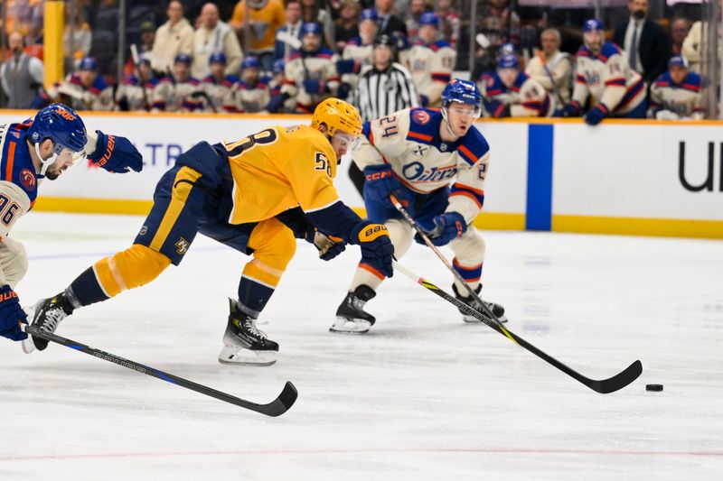Jan 13, 2026; Nashville, Tennessee, USA;  Nashville Predators left wing Michael Bunting (58) skates between Edmonton Oilers defenseman Jake Walman (96) and defenseman Spencer Stastney (24) during the first period at Bridgestone Arena. Mandatory Credit: Steve Roberts-Imagn Images