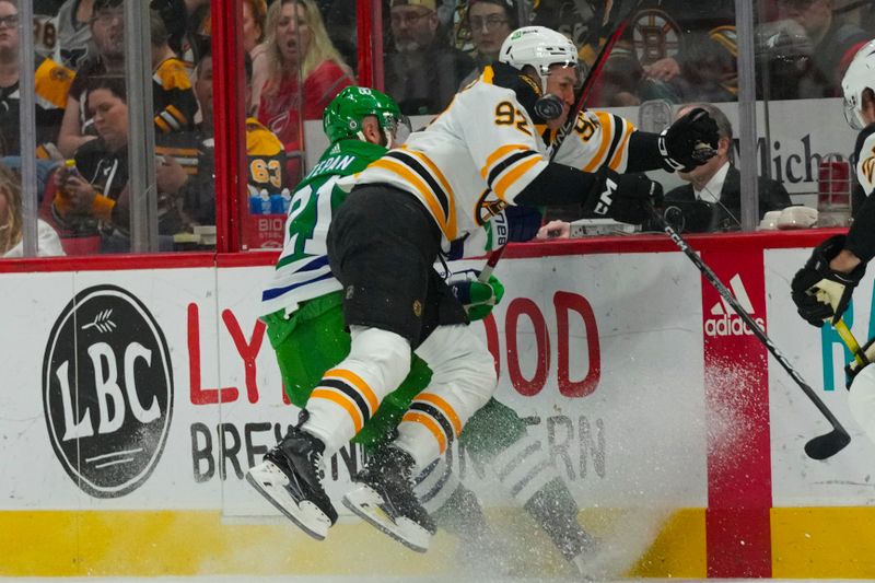 Mar 26, 2023; Raleigh, North Carolina, USA;  Boston Bruins left wing Tomas Nosek (92) checks Carolina Hurricanes center Derek Stepan (21) during the first period at PNC Arena. Mandatory Credit: James Guillory-USA TODAY Sports