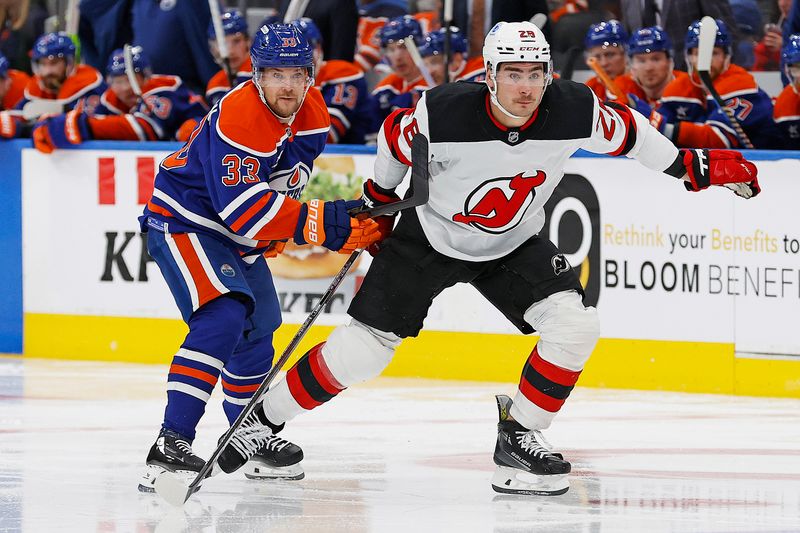 Nov 4, 2024; Edmonton, Alberta, CAN; New Jersey Devils forward Timo Meier (28) and Edmonton Oilers forward Victor Arvidsson (33) looks for a loose puck during the second period at Rogers Place. Mandatory Credit: Perry Nelson-Imagn Images