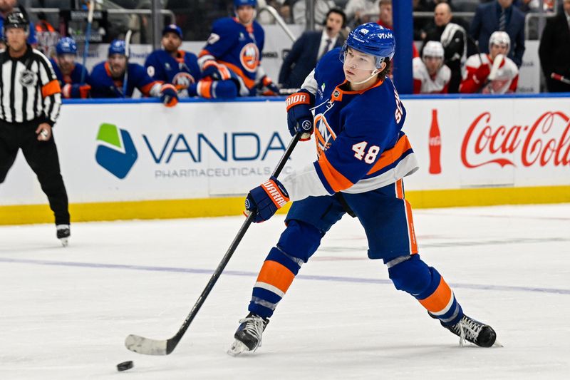 Oct 23, 2025; Elmont, New York, USA;  New York Islanders defenseman Matthew Schaefer (48) attempts a shot against the Detroit Red Wings during the second period at UBS Arena. Mandatory Credit: Dennis Schneidler-Imagn Images