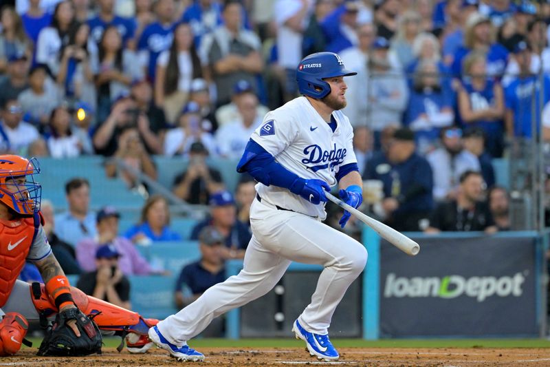 Oct 13, 2024; Los Angeles, California, USA; Los Angeles Dodgers third base Max Muncy (13) hits a two run single against the New York Mets during the first inning in game one of the NLCS for the 2024 MLB Playoffs at Dodger Stadium. Mandatory Credit: Jayne Kamin-Oncea-Imagn Images