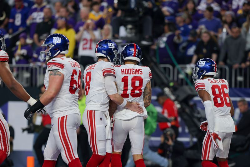 New York Giants quarterback Daniel Jones (8) talks to wide receiver Isaiah Hodgins (18) during the first half of an NFL wild-card football game against the Minnesota Vikings, Sunday, Jan. 15, 2023 in Minneapolis. (AP Photo/Stacy Bengs)