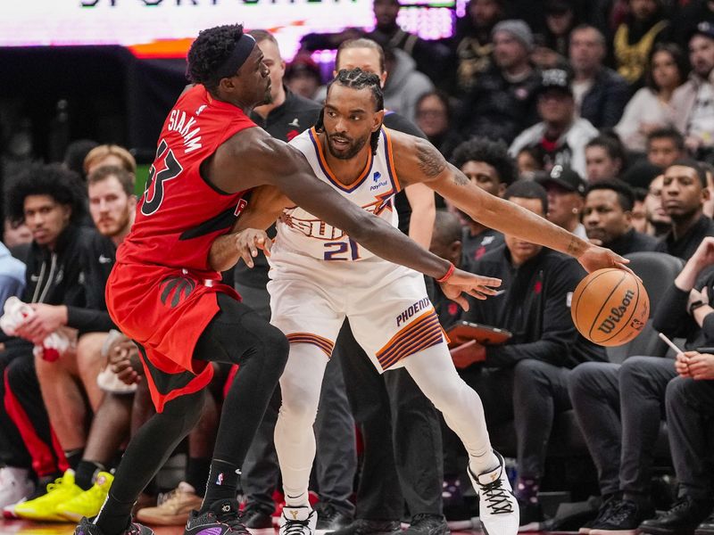 TORONTO, ON - NOVEMBER 29: Pascal Siakam #43 of the Toronto Raptors defends against Keita Bates-Diop #21 of the Phoenix Suns during second half action at the Scotiabank Arena on November 29, 2023 in Toronto, Ontario, Canada. NOTE TO USER: User expressly acknowledges and agrees that, by downloading and/or using this Photograph, user is consenting to the terms and conditions of the Getty Images License Agreement. (Photo by Andrew Lahodynskyj/Getty Images)