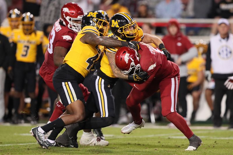 Nov 24, 2023; Fayetteville, Arkansas, USA; Arkansas Razorbacks quarterback Jacolby Criswell (6) is sacked by Missouri Tigers defensive lineman Joe Moore III (45) and linebacker Chuck Hicks (30) during the second half at Donald W. Reynolds Razorback Stadium. Missouri won 48-14. Mandatory Credit: Nelson Chenault-USA TODAY Sports