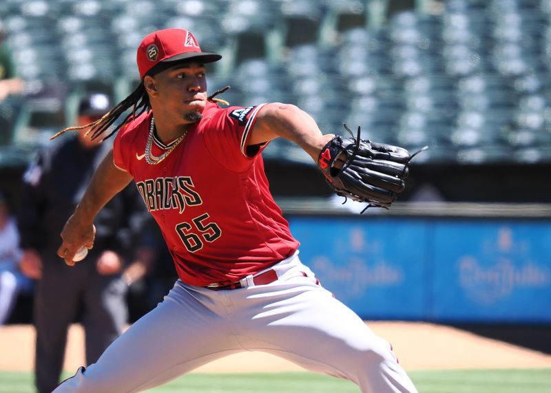 May 17, 2023; Oakland, California, USA; Arizona Diamondbacks relief pitcher Luis Frias (65) pitches the ball against the Oakland Athletics during the sixth inning at Oakland-Alameda County Coliseum. Mandatory Credit: Kelley L Cox-USA TODAY Sports