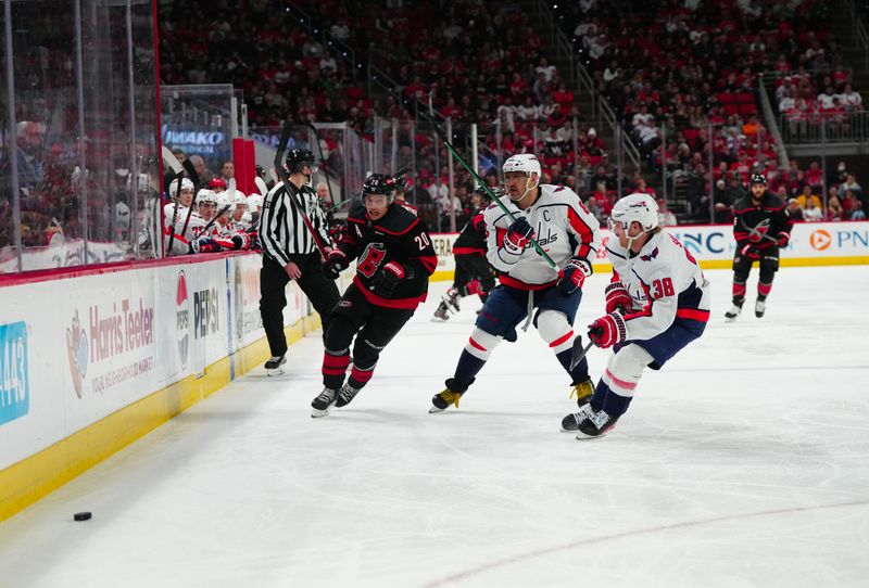 Apr 5, 2024; Raleigh, North Carolina, USA; Carolina Hurricanes center Sebastian Aho (20) Washington Capitals defenseman Rasmus Sandin (38) and left wing Alex Ovechkin (8) chase after the puck during the third period at PNC Arena. Mandatory Credit: James Guillory-USA TODAY Sports