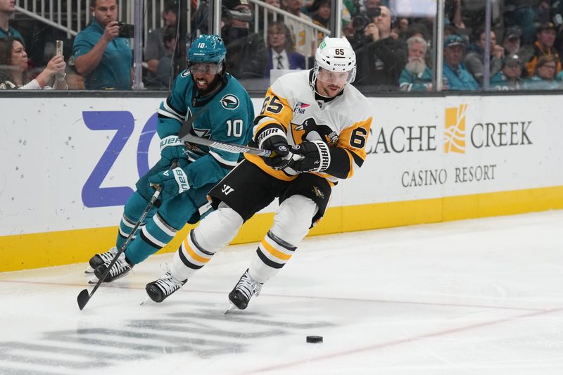 Nov 4, 2023; San Jose, California, USA; Pittsburgh Penguins defenseman Erik Karlsson (65) skates with the puck against San Jose Sharks left wing Anthony Duclair (10) during the second period at SAP Center at San Jose. Mandatory Credit: Darren Yamashita-USA TODAY Sports