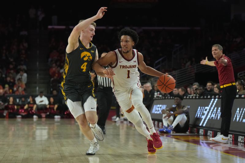 Jan 14, 2025; Los Angeles, California, USA; Southern California Trojans guard Desmond Claude (1) dribbles the ball against Iowa Hawkeyes guard Josh Dix (4) in the second half at the Galen Center. Mandatory Credit: Kirby Lee-Imagn Images