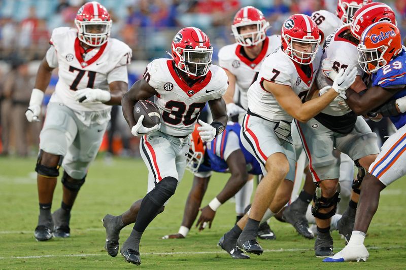 Oct 28, 2023; Jacksonville, Florida, USA; Georgia Bulldogs running back Daijun Edwards (30) runs the ball in the second half against the Florida Gators at EverBank Stadium. Mandatory Credit: Jeff Swinger-USA TODAY Sports