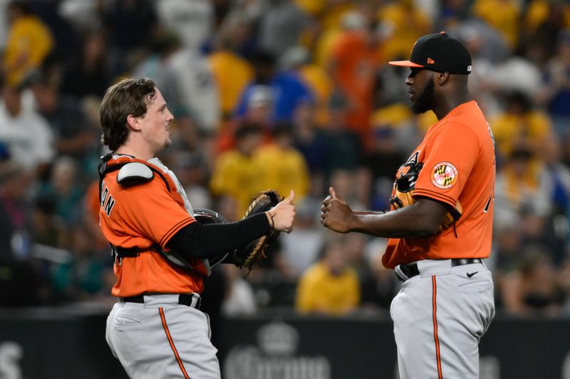 Aug 12, 2023; Seattle, Washington, USA; Baltimore Orioles catcher Adley Rutschman (35) and relief pitcher Felix Bautista (74) celebrate defeating the Seattle Mariners during the tenth inning at T-Mobile Park. Mandatory Credit: Steven Bisig-USA TODAY Sports