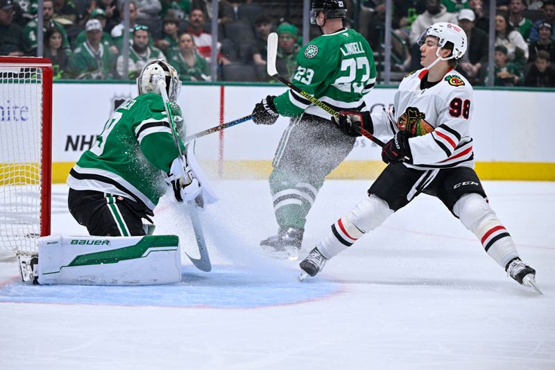 Nov 7, 2024; Dallas, Texas, USA; Dallas Stars goaltender Jake Oettinger (29) stops a shot by Chicago Blackhawks center Connor Bedard (98) during the first period at the American Airlines Center. Mandatory Credit: Jerome Miron-Imagn Images