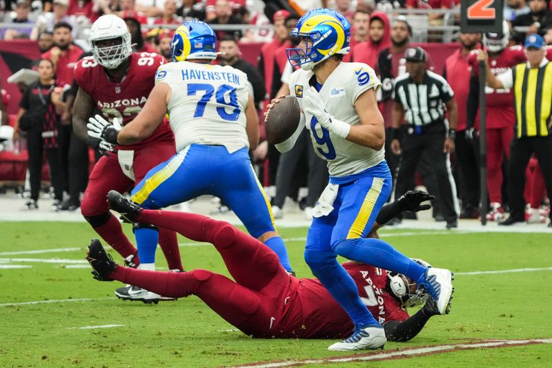 Los Angeles Rams quarterback Matthew Stafford (9) runs away from Arizona Cardinals linebacker Kyzir White (7) in the pocket during the first half of an NFL football game, Sunday, Sept. 15, 2024, in Glendale, Ariz. (AP Photo/Rick Scuteri)