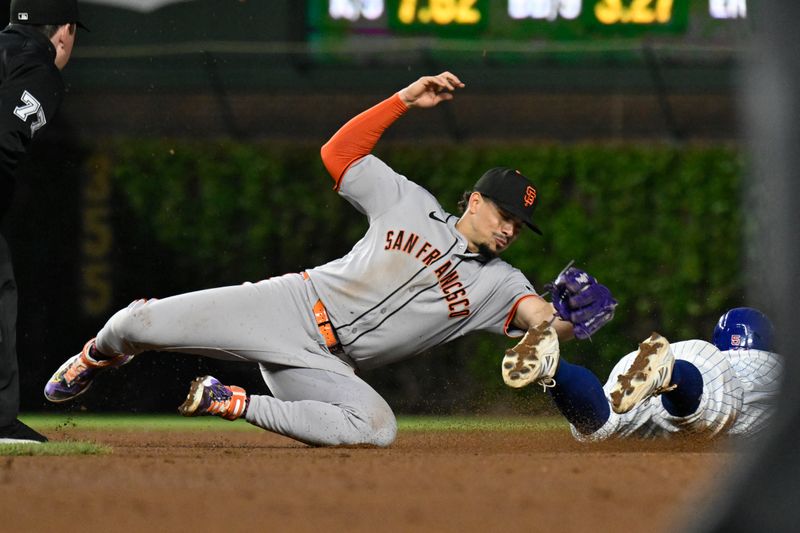 May 6, 2025; Chicago, Illinois, USA;  Chicago Cubs second baseman Jon Berti (5) is caught stealing second base bye San Francisco Giants shortstop Willy Adames (2) during the fifth inning  at Wrigley Field. Mandatory Credit: Matt Marton-Imagn Images