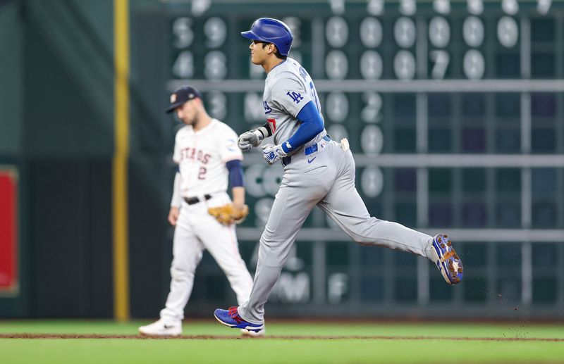 Jul 27, 2024; Houston, Texas, USA; Houston Astros third baseman Alex Bregman (2) reacts and Los Angeles Dodgers designated hitter Shohei Ohtani (17) rounds the bases after hitting a home run during the third inning at Minute Maid Park. Mandatory Credit: Troy Taormina-USA TODAY Sports