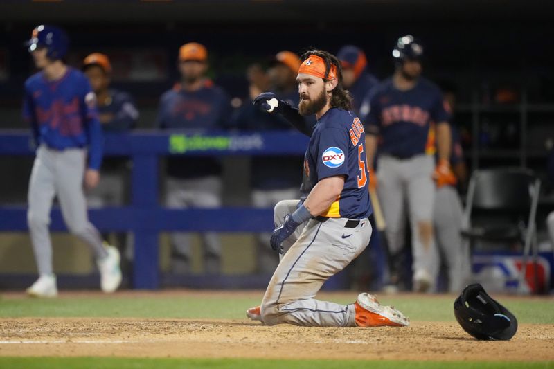 Mar 6, 2025; Port St. Lucie, Florida, USA;  Houston Astros second baseman Brendan Rodgers (54) looks back after sliding around the tag of New York Mets catcher Francisco Alvarez (4) to score a run in the fourth inning at Clover Park. Mandatory Credit: Jim Rassol-Imagn Images