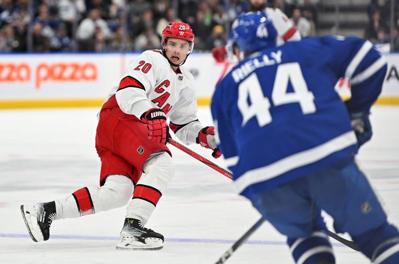 Dec 30, 2023; Toronto, Ontario, CAN; Carolina Hurricanes forward Sebastian Aho (20) moves to block a rush up ice by Toronto Maple Leafs defenseman Morgan Rielly (44) in the second period at Scotiabank Arena. Mandatory Credit: Dan Hamilton-USA TODAY Sports