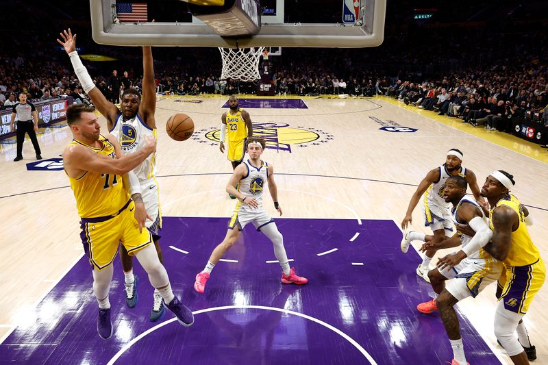 LOS ANGELES, CALIFORNIA - APRIL 03: Luka Doncic #77 of the Los Angeles Lakers passes against Kevon Looney #5 of the Golden State Warriors during the second half of a game at Crypto.com Arena on April 03, 2025 in Los Angeles, California. NOTE TO USER: User expressly acknowledges and agrees that, by downloading and or using this photograph, User is consenting to the terms and conditions of the Getty Images License Agreement. (Photo by Michael Owens/Getty Images)