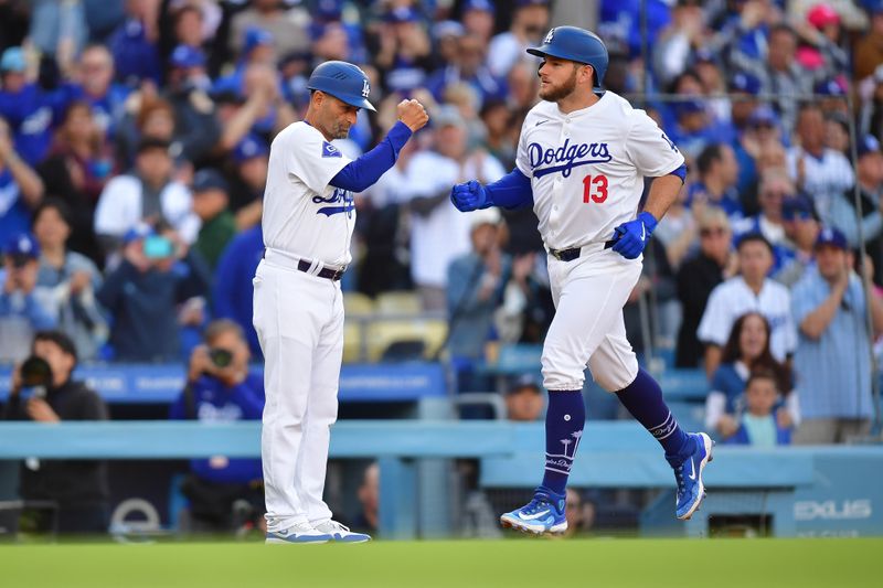 May 4, 2024; Los Angeles, California, USA; Los Angeles Dodgers third baseman Max Muncy (13) is greeted by third base coach Dino Ebel (91) after hitting a two run home run against the Atlanta Braves during the second inning at Dodger Stadium. Mandatory Credit: Gary A. Vasquez-USA TODAY Sports