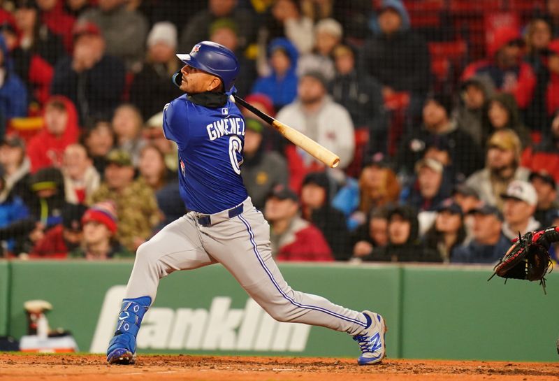 Apr 7, 2025; Boston, Massachusetts, USA; Toronto Blue Jays second base Andrés Giménez (0) hits a sacrifice fly ball to center field to drive in a run against the Boston Red Sox in the third inning at Fenway Park. Mandatory Credit: David Butler II-Imagn Images