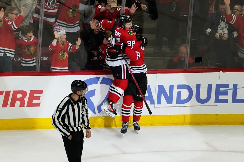 Nov 24, 2023; Chicago, Illinois, USA; Chicago Blackhawks defenseman Kevin Korchinski (55) celebrates with center Connor Bedard (98) after the game winning goal during an overtime period against the Toronto Maple Leafs at United Center. Mandatory Credit: David Banks-USA TODAY Sports